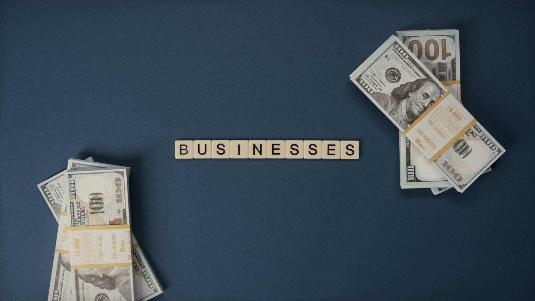 Banknoty dolarowe i kostki z napisem businesses z góry