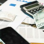 Rachunki telefoniczne, kalkulator i banknoty złotowe na biurku