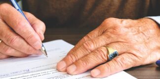 Prawo do odstąpienia od umowy dla seniora: 14 dni, 30 dni czy więcej – co naprawdę przysługuje Dłoń seniora z obrączką podpisująca dokument prawny